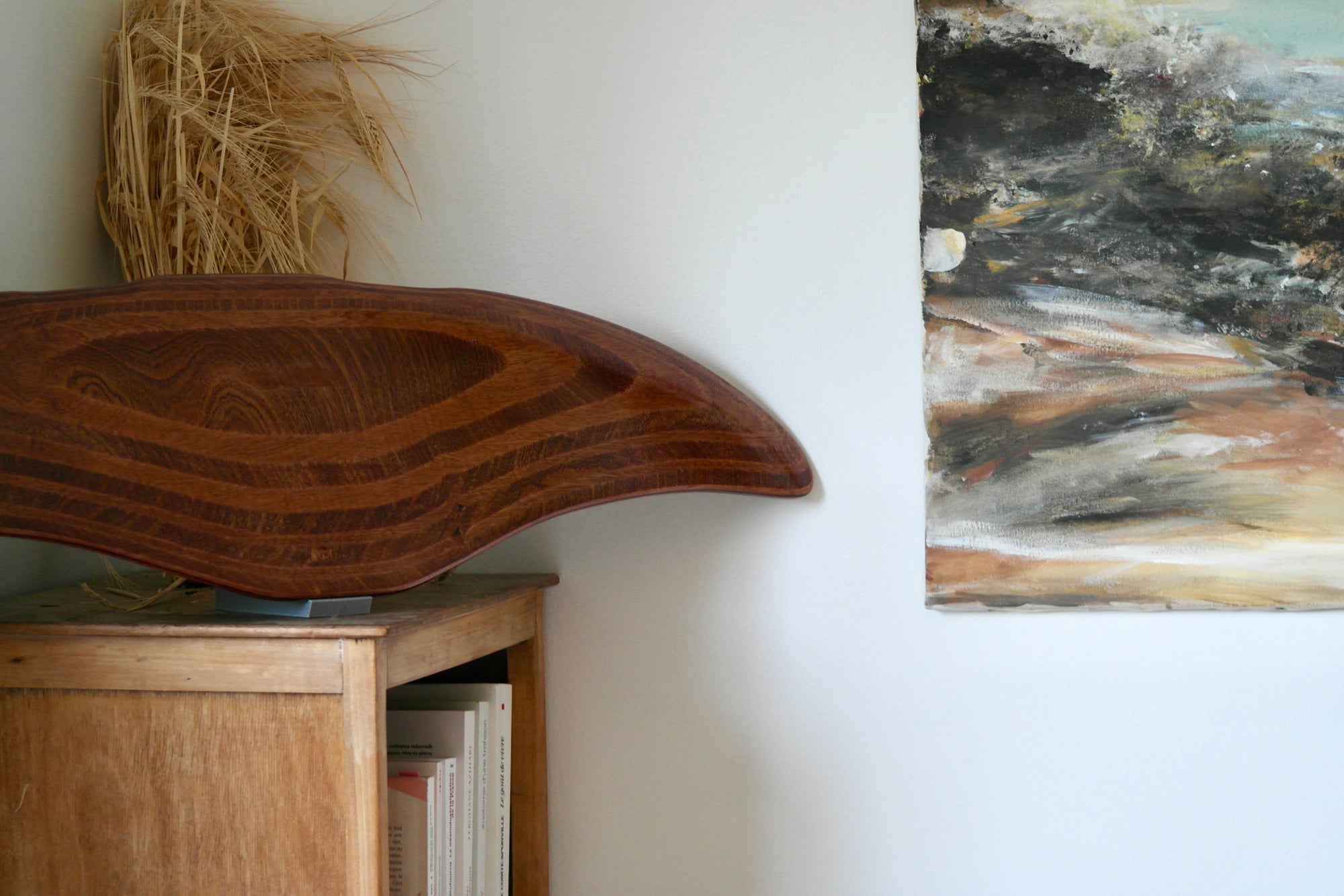 DeepFoil en bois (ou Deep Foil) exposé sur une commode sur son support à coté d'un tableau  