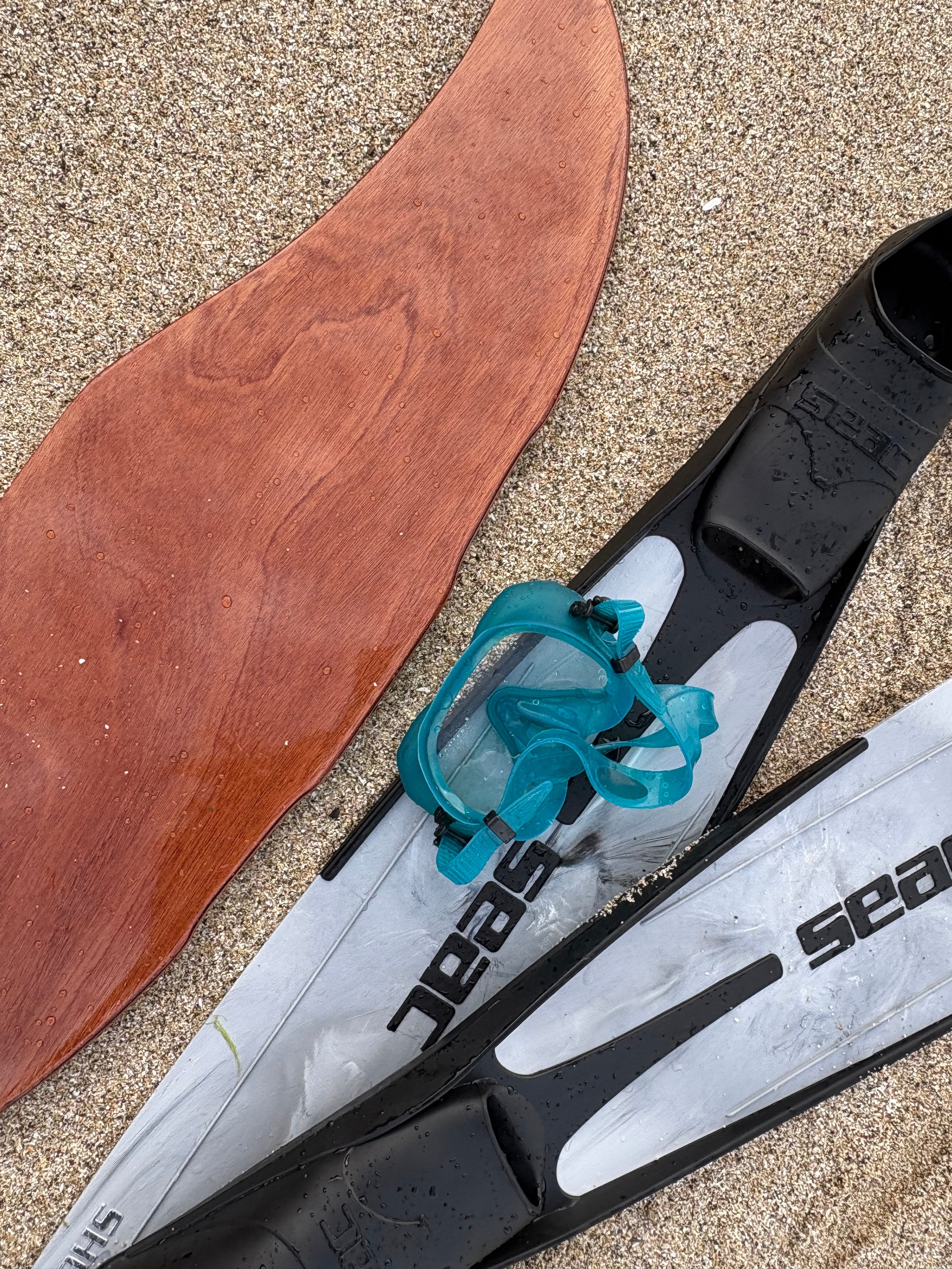 DeepFoil (ou Deep Foil)en bois posé sur la plage avec des palmes et un masque